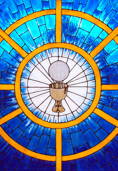 Eucharist over raised Chalice in front of stained glass window