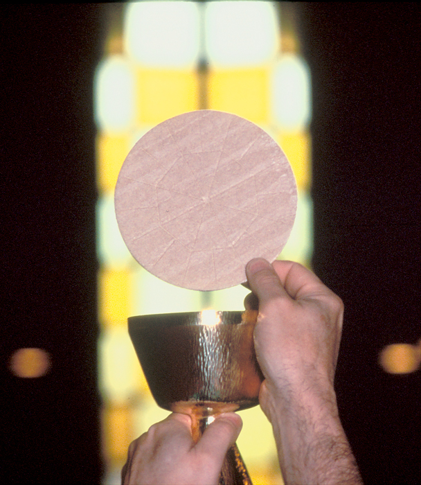 Final elevation of the Holy Eucharist over a gold chalice